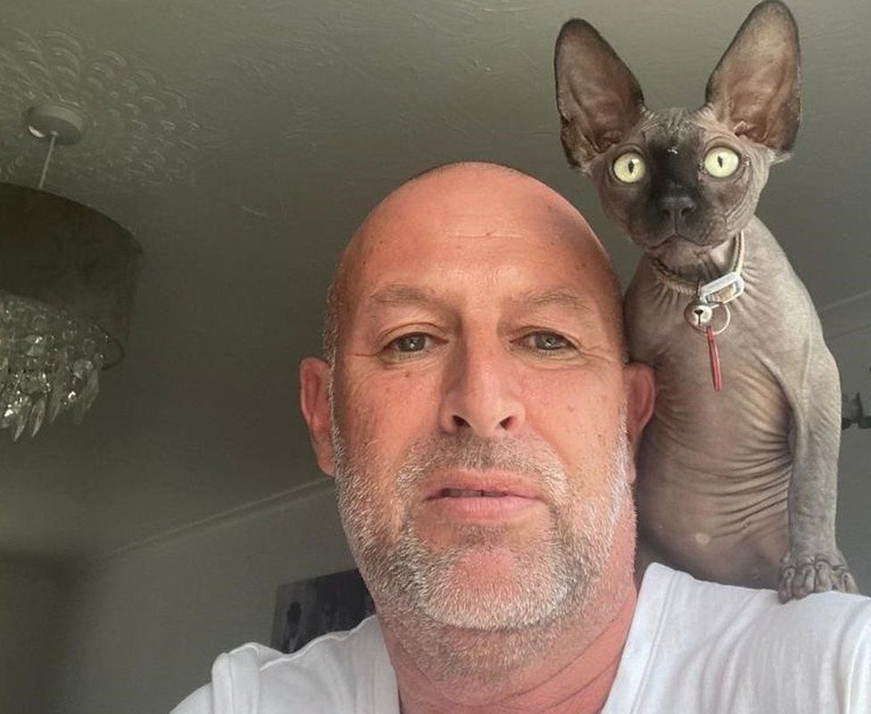 Chris Rowley with his pet cat Eric