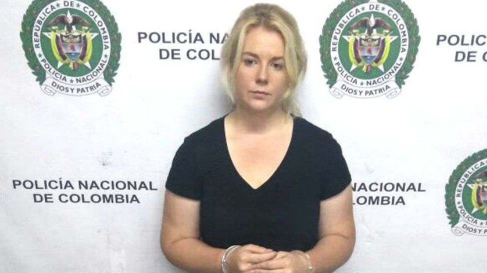 Cassie Sainsbury stands in front of a police banner soon after her arrest