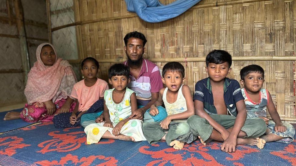 Mohammad Rafique (centre) and his family in a bamboo shelter for refugees
