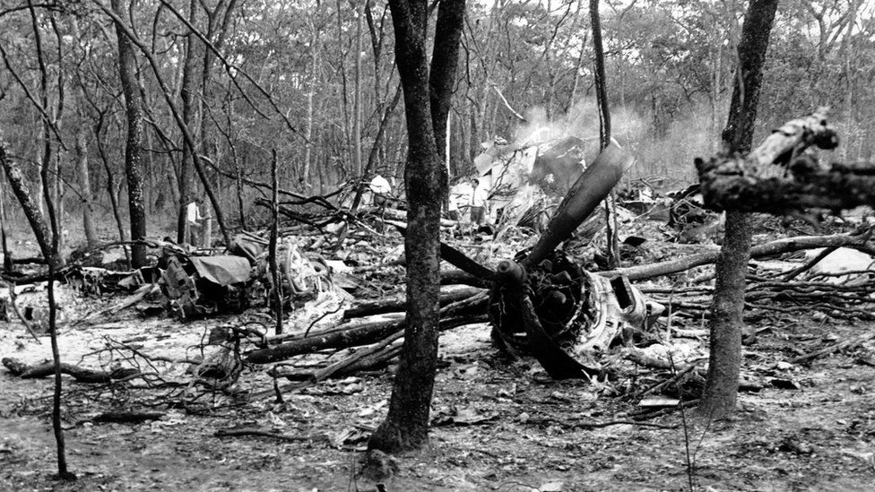 Searchers walk through wreckage of the DC6 plane carrying Dag Hammarskjold in a forest near Ndola, Zambia. 19 Sept 1961