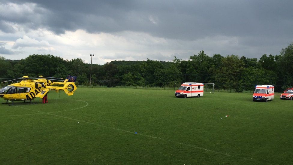 Photo provided by police shows helicopter, two ambulances and further emergency vehicles on football pitch, with dark grey skies (28 May 2016)
