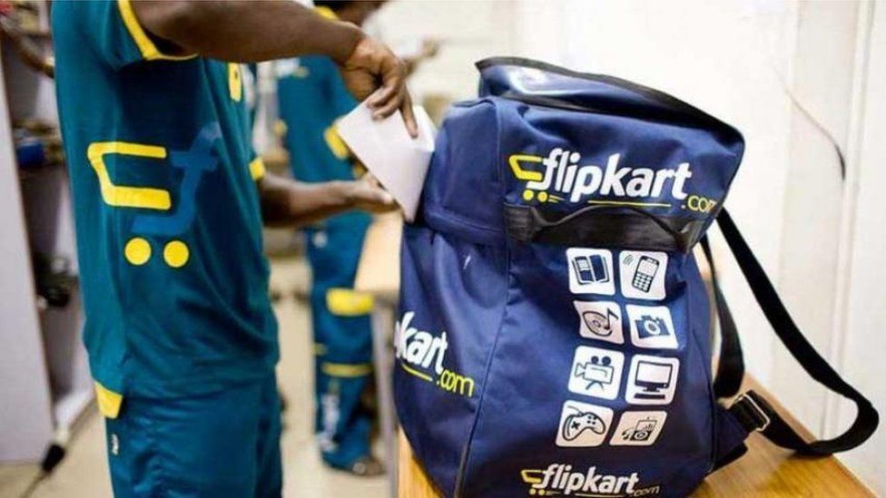A delivery boy packs his Flipkart bag.