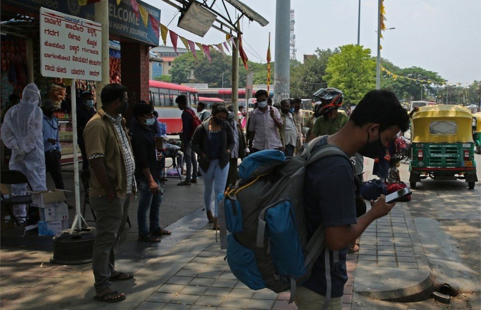 Indian migrant workers travelling back to their home towns at the city bus stand in Bangalore, on 26 April 2021