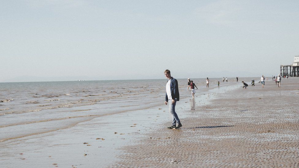 Mark Newsome walking on the beach at Blackpool