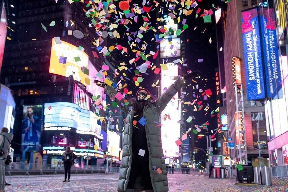 A woman throws confetti during the 2021 New Year's Eve celebrations on 1 January, 2020 in New York City