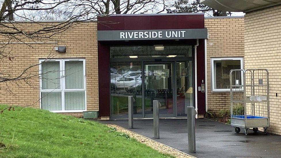 Entrance to the Riverside unit showing double doors in a brick building