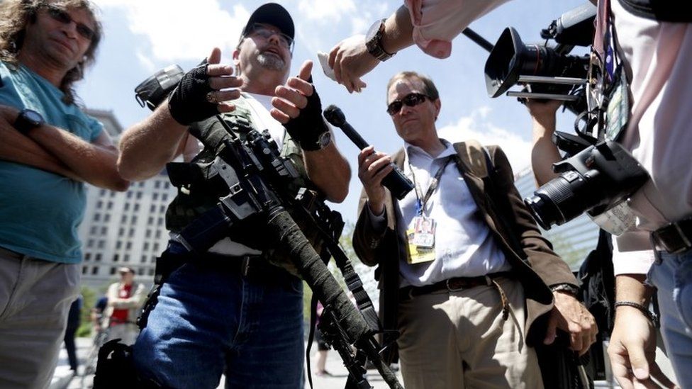 Second Amendment supporter Steve Thacker carries an AR-15-style weapon as he talks to the media during a protest
