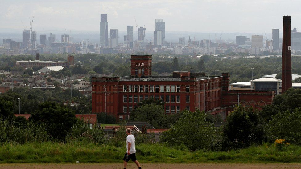 Manchester city centre in background, Oldham in foreground with man walking past