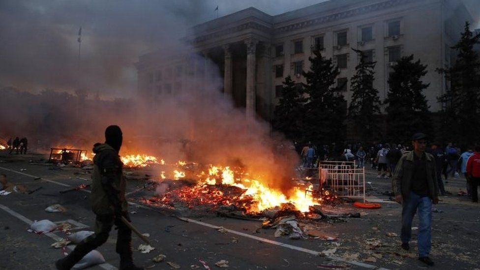 A protester walks past burning tents near Odessa's trade union building. Photo: 2 May 2014