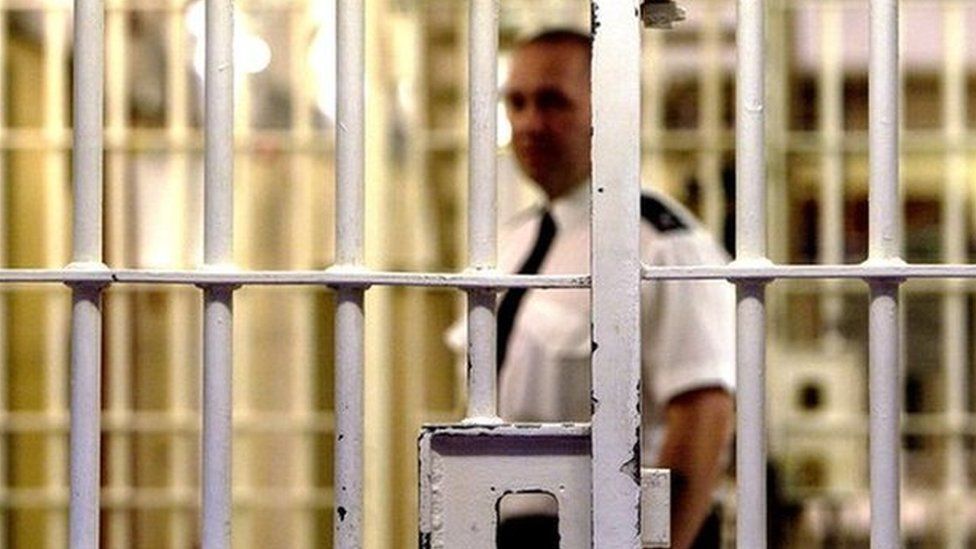 Stock picture of a prison officer and a jail cell