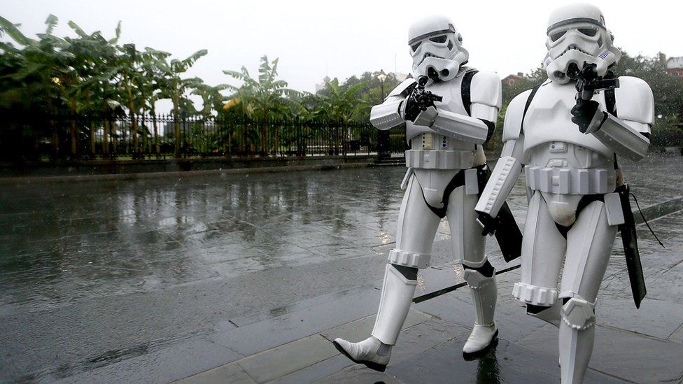 A pair of Storm Troopers walk through Jackson Square in the French Quarter of New Orleans, Louisiana, as strong winds and heavy rain from Hurricane Nate begin to come ashore, 7 October 2017