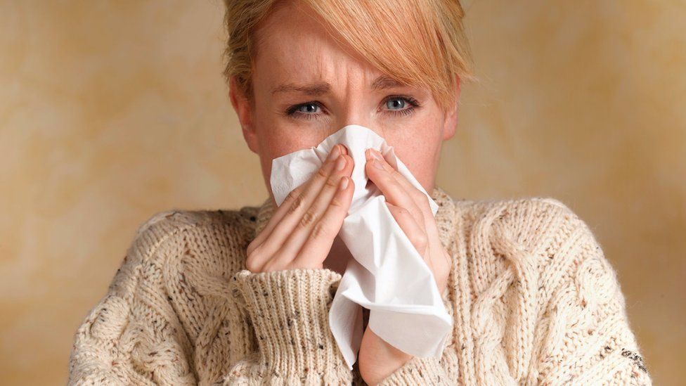 Woman blowing her nose