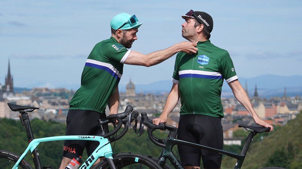 Davy's twin brother Tommy Zyw helping him zip up his cycling shirt