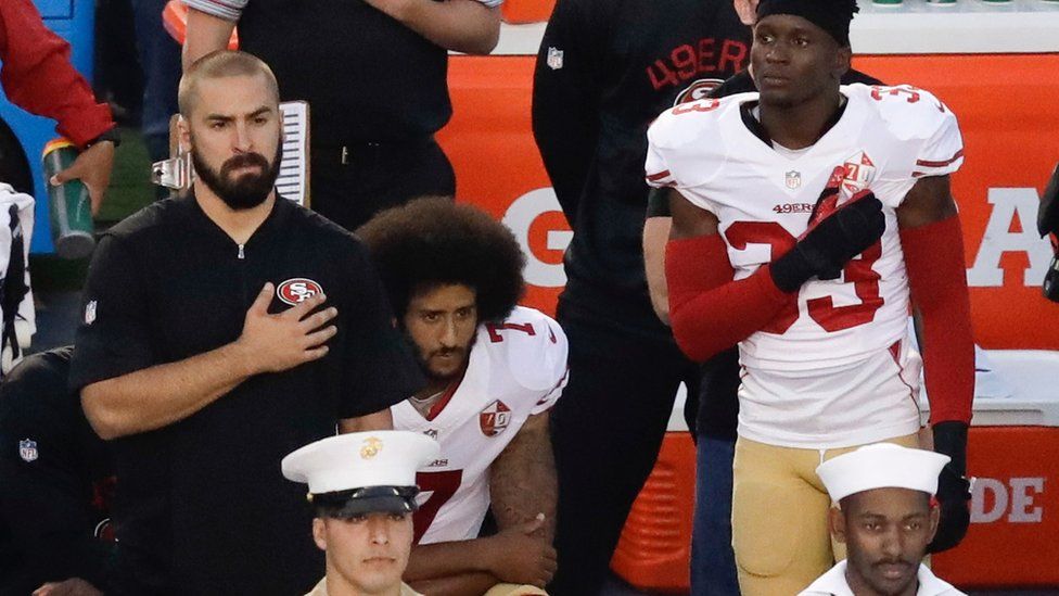San Francisco 49ers quarterback Colin Kaepernick, middle, kneels during the national anthem before the team"s NFL preseason football game against the San Diego Chargers, Thursday, Sept. 1, 2016
