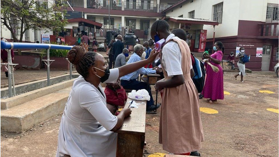 Ugandan student getting their temperature checked