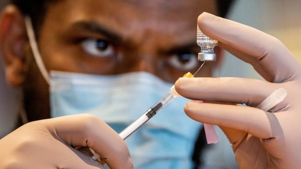 A healthcare worker prepares a dose of the Pfizer/BioNTech coronavirus disease