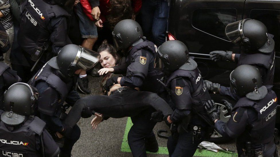 Spanish National riot police evict a young woman during clashes between the people gathered outside the Ramon Llull school and police forces in Barcelona, Catalonia, on 01 October 2017.