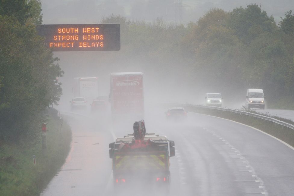 A weather warning sign alerts drivers travelling through water spray and winds on the M5 motorway network as Storm Ciaran brings high winds and heavy rain along the south coast of England. November 2, 2023