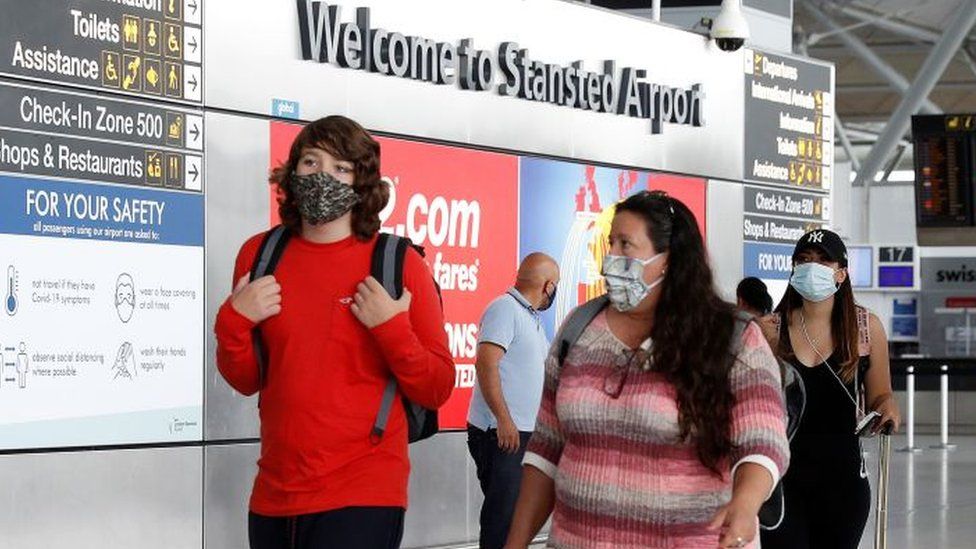 People with facemasks at Stansted Airport