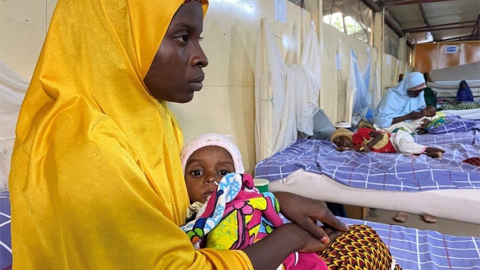 ผู้หญิงคนหนึ่งอุ้มเด็กที่ขาดสารอาหารที่ศูนย์บำบัดใน Damaturu เมือง Yobe ประเทศไนจีเรีย 24 สิงหาคม 2022