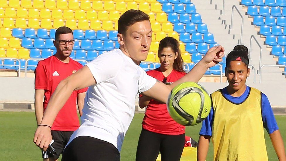 Mesut Ozil (C) plays with members of the women's U-17 Jordanian national football team