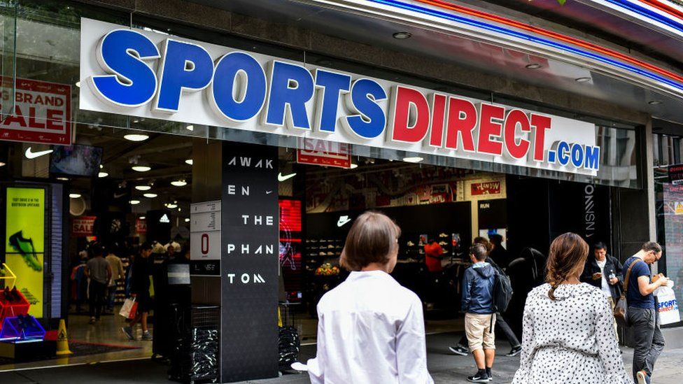 Shoppers passing a Sports Direct shop