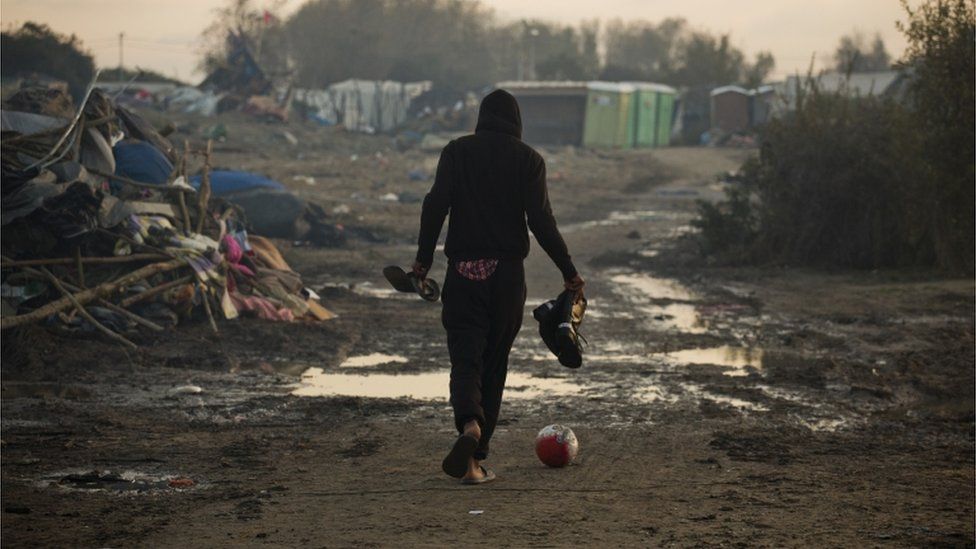 A man walks across Calais migrant camp