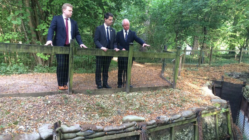NI Secretary James Brokenshire (centre) with DUP MLA Alastair Ross (left) being shown around the trenches in Thiepval Wood
