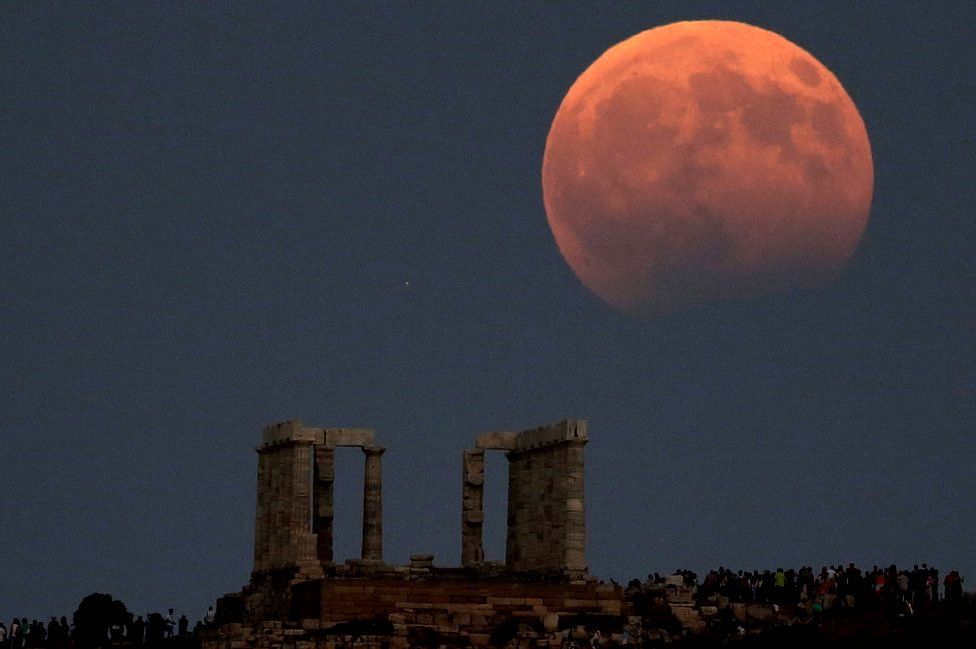 Temple of Poseidon is seen as a full moon is partially covered by the Earth's shadow during a lunar eclipse in Cape Sounion, east of Athens, Greece, August 7, 2017