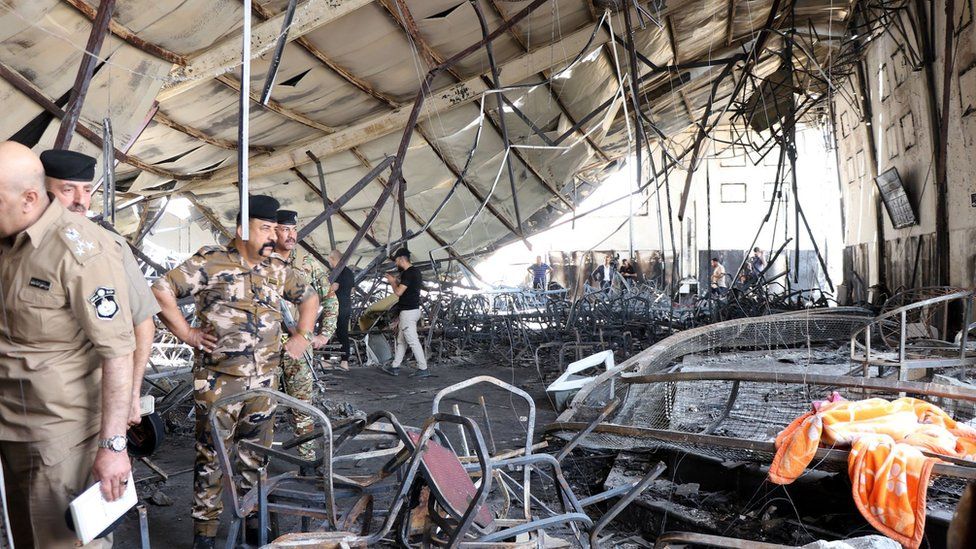 Officials inspect the burned-out interior of the al-Haitham Hall in Qaraqosh, northern Iraq (27 September 2023)