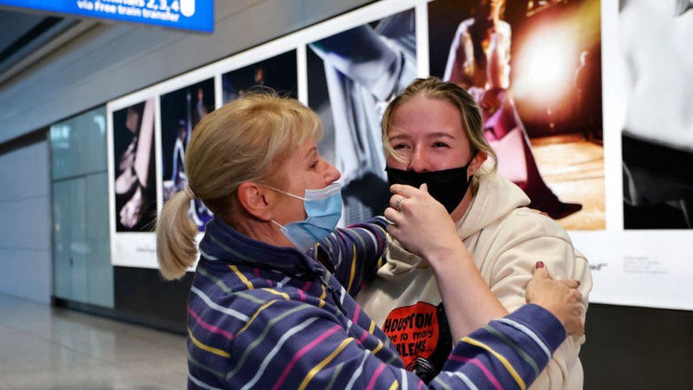 Relatives embrace as they arrive from the United States at Heathrow's Terminal 5