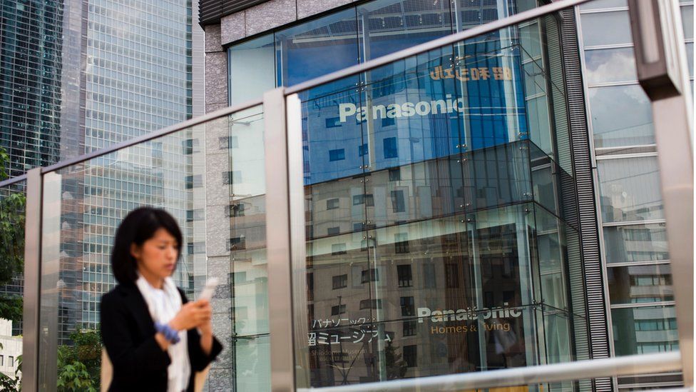 A woman walks past a Panasonic building in Tokyo on May 11, 2017.