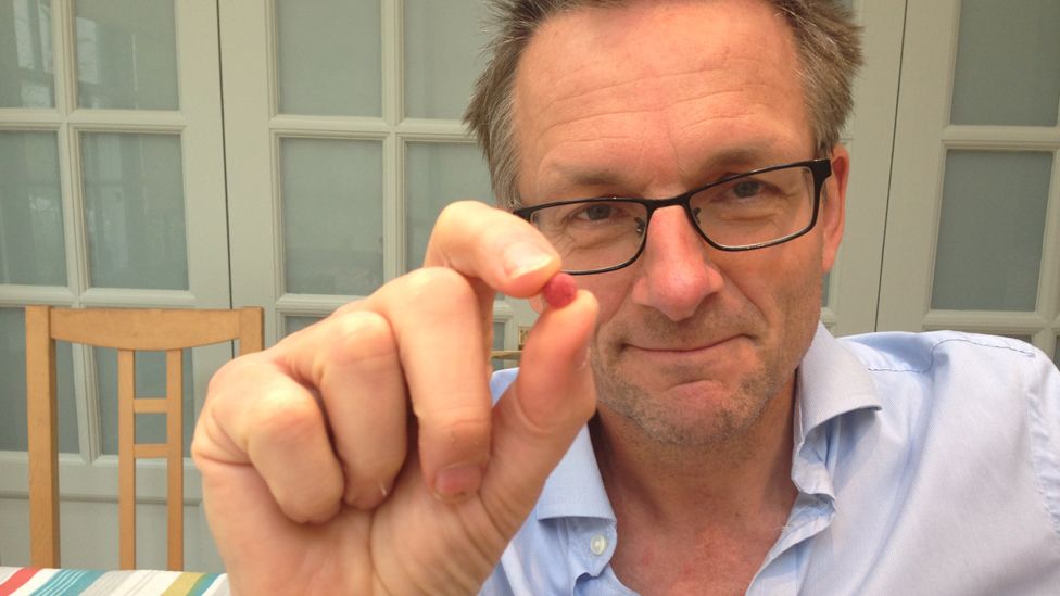 Michael Mosley holds up a miracle berry pill