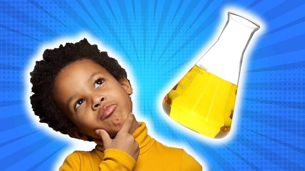 Child looking curious, next to beaker of yellow fluid