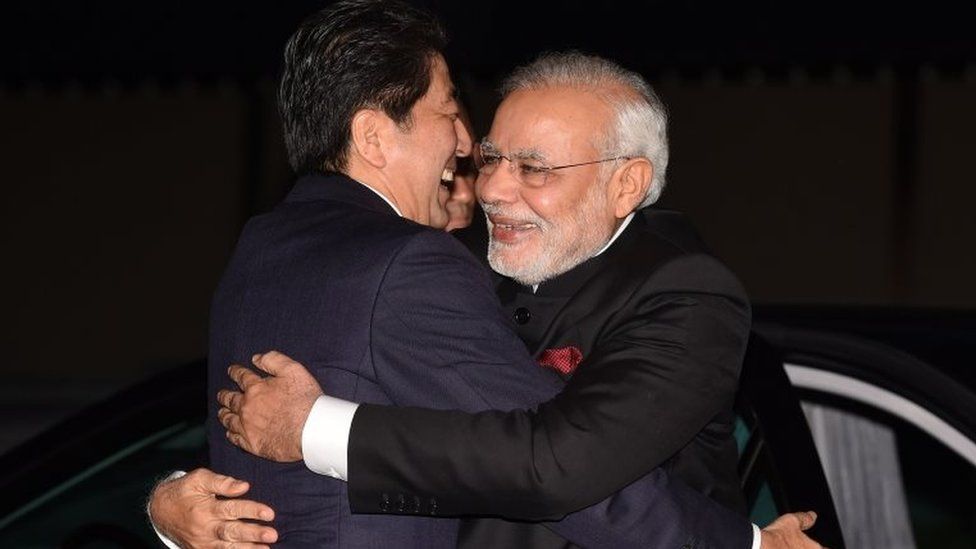 India's Prime Minister Narendra Modi (R) is embraced by his Japanese counterpart Shinzo Abe upon his arrival at the State Guest House in Kyoto.
