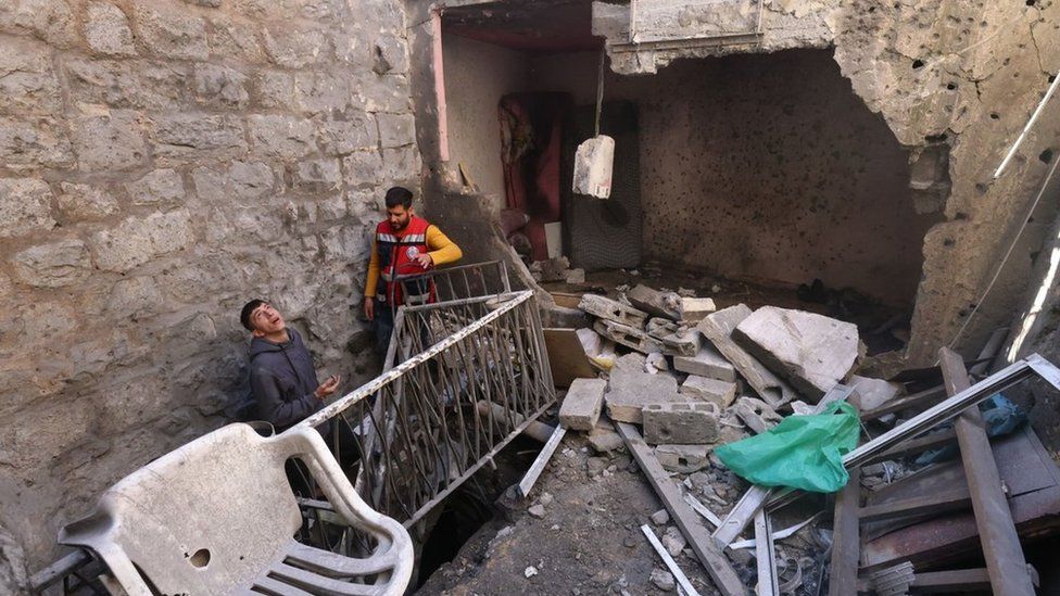 Palestinians inspect the damaged house where Israeli forces killed three Palestinians during a raid in the old city of Nablus (4 May 2023)