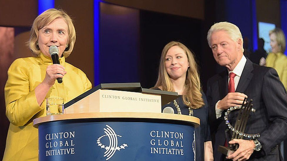 Chelsea and Bill Clinton watch Hillary Clinton at a meeting of the Clinton Global Initiative