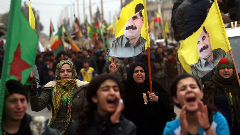 Syrian Kurds carry portraits of jailed PKK leader Abdullah Ocalan and YPG flags as they protest in support of Afrin in the Syrian town of Jawadiyah (18 January 2018)