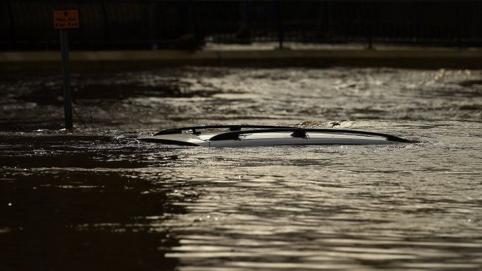 The roof of a submerged car is pictured in a flooded street in Mytholmroyd, northern England