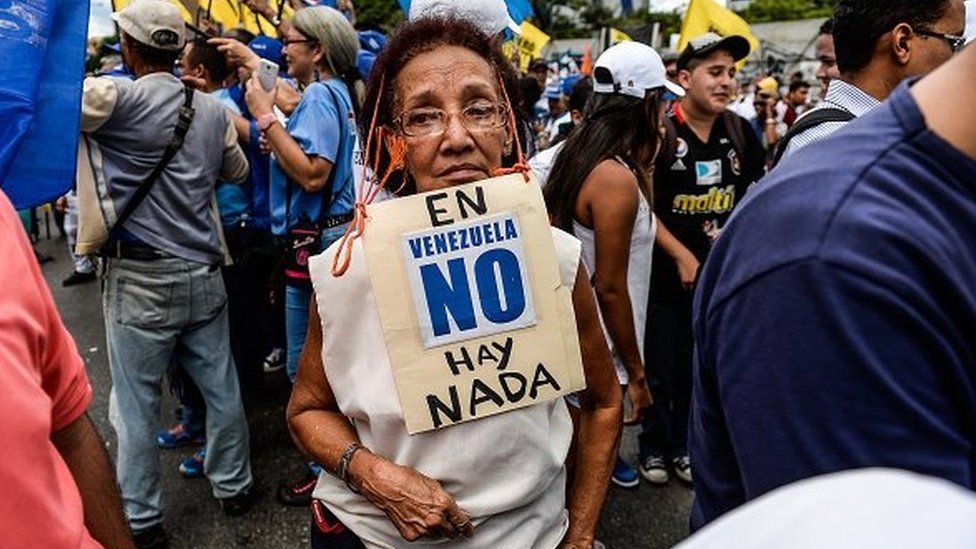 A Venezuelan opposition activist carries a poster reading: "There is Nothing in Venezuela" during a peaceful rally against crime and shortages in the country, in Caracas, on 8 August, 2015