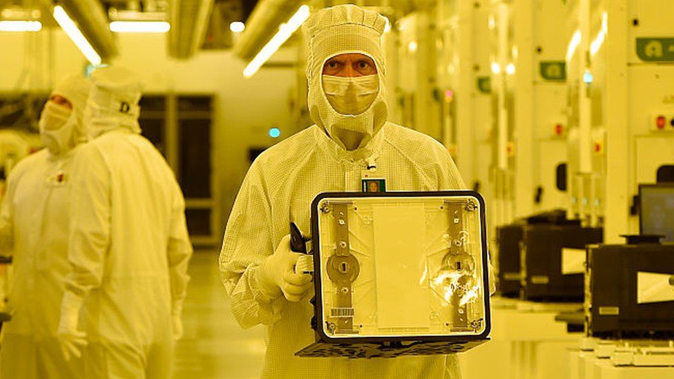 System engineers supervise the production line for 300mm wafers in a clean room at the GlobalFoundries semiconductor manufacturing plant on July 14, 2015 in Dresden, Germany.