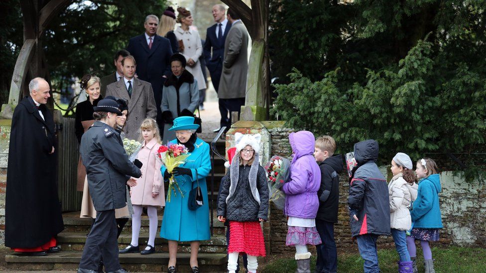Queen Elizabeth II receiving flowers from children after she attended St Mary Magdalene Church, on the royal estate in Sandringham, Norfolk in 2012