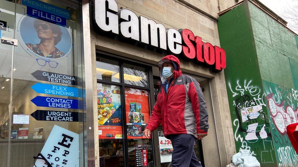 Мужчина идет перед магазином GameStop в районе Джексон-Хайтс в Нью-Йорке, штат Нью-Йорк, США, 27 января 2021 года. Фотография сделана 27 января 2021 года