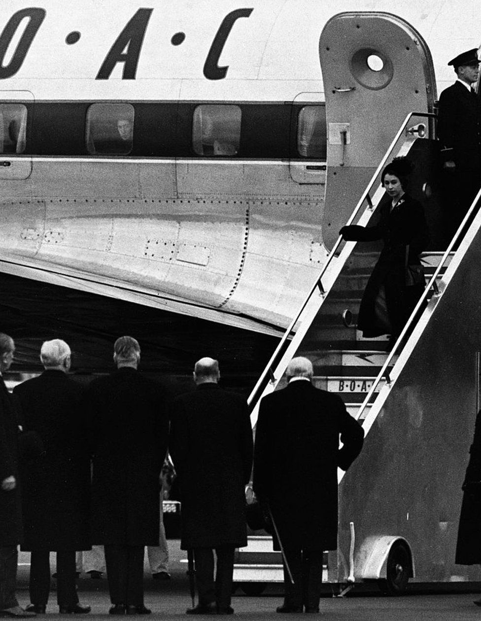 The Queen arrives back in Britain from Nairobi following the death of her father George VI, and is met by the politicians (second l to r) Lord Woolton, Anthony Eden, Clement Atlee and Winston Churchill.