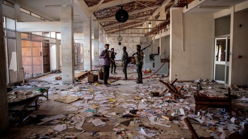 Amhara Fano militia fighters walk in the ransacked terminal at the Lalibela airport in Lalibela, o++n December 7, 2021