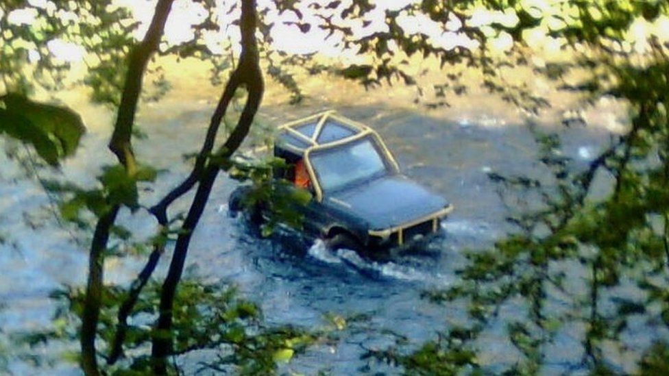 A 4x4 driving through the river Usk