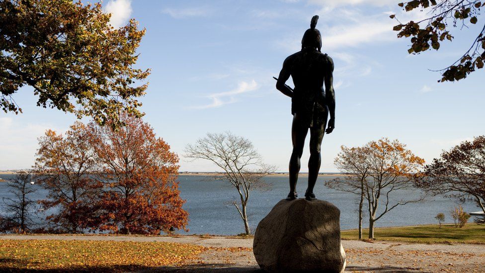 Статуя Вампаноагса стоит на холме с видом на гавань Плимута в Массачусетсе.