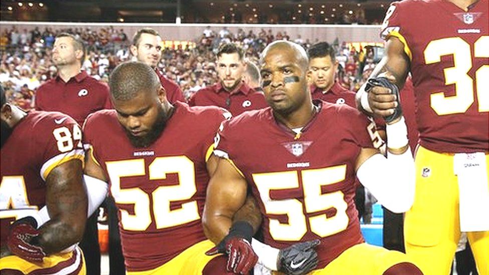 Washington Redskins players, some kneeling, during the anthem before a game against the Oakland Raiders