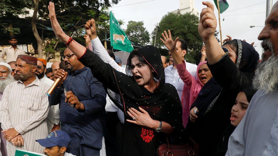PML-N supporters raise their hands in protest in Karachi on 13 July
