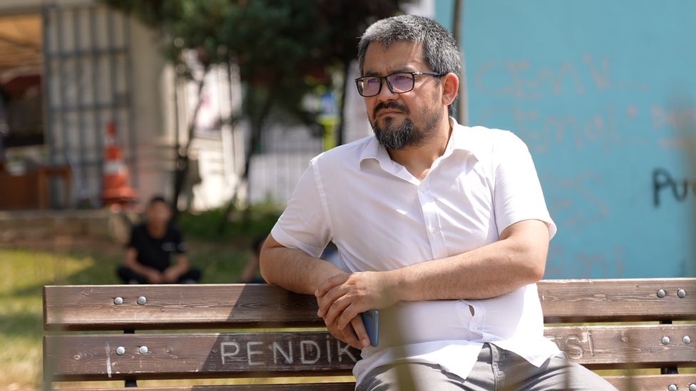 Абдурехим Парач сидит на скамейке в солнечном свете в Стамбуле